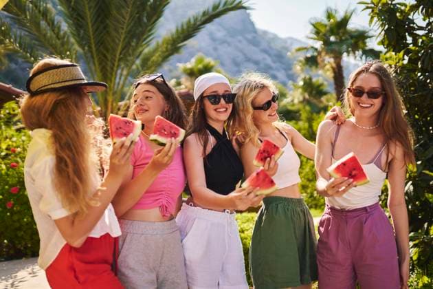 Cheerful friends standing with watermelon on sunny day on vacation model released, Symbolfoto property released, ANNF00403