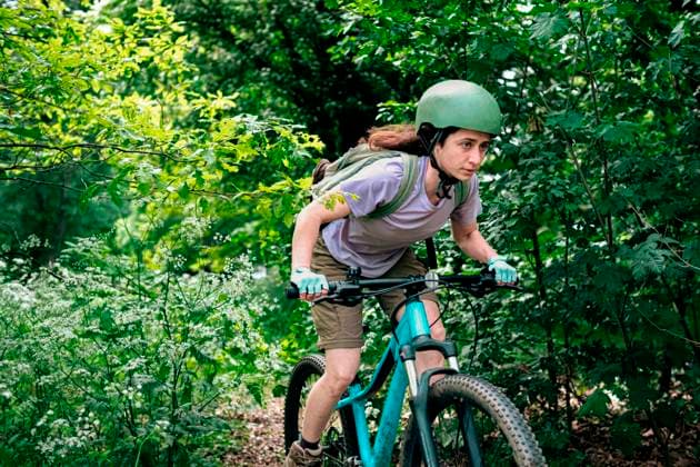 Young woman riding bicycle in forest model released, Symbolfoto, AMWF01657