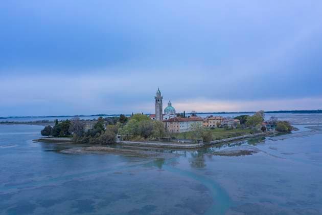 Italy, Friuli Venezia Giulia, Aerial view of Barbana island and Santuario di Barbana at dusk, HAMF00877