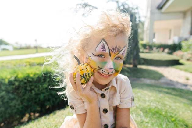 Creative Highlights Symbolbilder Happy girl with face painting holding small pumpkin on sunny day model released, Symbolfoto, SIF00910