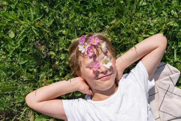 IMAGO Creative: Sommer, Sommertage im Garten Happy boy with flowers on forehead and eyes on sunny day model released, Symbolfoto, VBUF00366