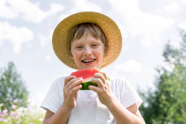 Happy boy standing with slice of watermelon model released, Symbolfoto, VBUF00369
