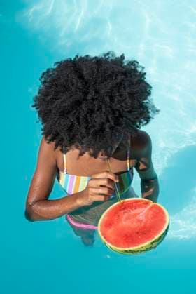 Creative Highlights Symbolbilder Woman drinking watermelon juice in pool model released, Symbolfoto, VRAF00186
