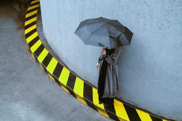Creative Highlights Symbolbilder Woman holding umbrella standing near wall model released, Symbolfoto, YHF00093