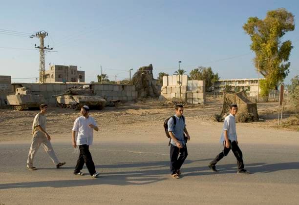 Isarel. Gaza strip. Gush Katif (settlements). Kfar Darom. youngsters walking passed army vehicles Isarel. Gaza strip. Gush Katif (settlements). Kfar Darom. youngsters walking passed army vehicles, Credit:Eitan Simanor Avalon  Copyright: xEitanxSimanorx xAvalonx 0512132817