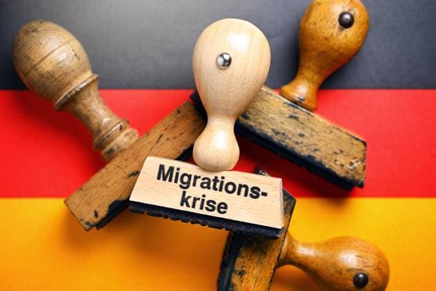 FOTOMONTAGE, Stempel mit Aufschrift Migrationskrise auf deutscher Fahne *** PHOTOMONTAGE, stamp with inscription migration crisis on German flag ** NUR FUER REDAKTIONELLE ZWECKE ** EDITORIAL USE ONLY **