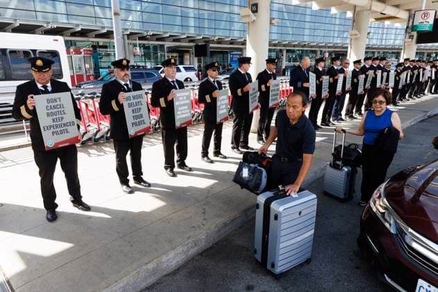 September 29, 2023, TORONTO, ON, Canada: Travellers walk by a demonstration of Air Canada pilots outside Pearson International Airport in Toronto, as their union is calling for an updated contract for the pilots, Friday, Sept. 29, 2023. TORONTO Canada  - ZUMAc35_ 20230929_zaf_c35_037 Copyright: xColexBurstonx