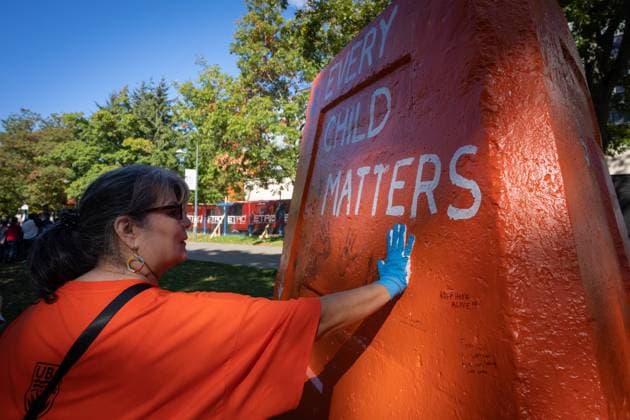 September 30, 2023, VANCOUVER, BC, CANADA: Marie Laboucan paints her handprint on the Engineering cairn during a march at the University of British Columbia for National Day for Truth and Reconciliation in Vancouver, B.C., Saturday, Sept. 30, 2023. VANCOUVER CANADA  - ZUMAc35_ 20230930_zaf_c35_158 Copyright: xEthanxCairnsx