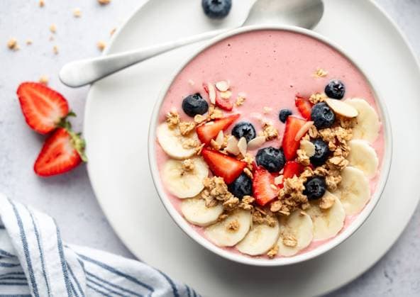 Top view of smoothie bowl with fruit and granola on gray background. Kingston, Ontario, Canada CR_DOHO2309283B-1261112-01