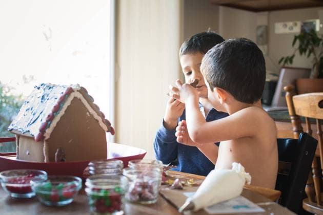 Young boys sampling candy while decorating a gingerbread house. Washington, District of Columbia, United States R_YWPB231001E-1260474-01 ,model released, Symbolfoto