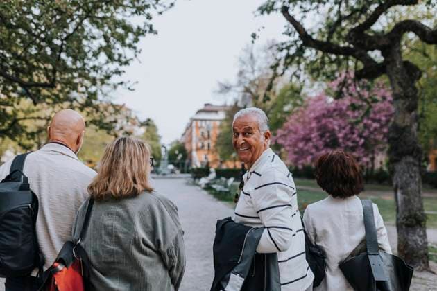 Portrait of smiling senior man looking over shoulder while walking with friends at park Sweden, Stockholm, model released Copyright: xMaskotx , MA103816 MA103816