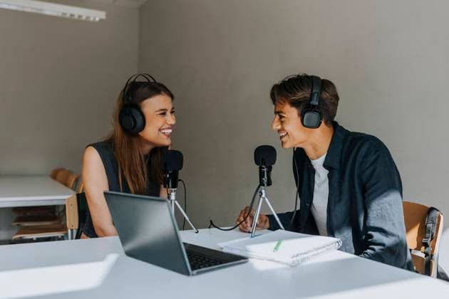 Happy male and female students looking at each other during podcasting in classroom Sweden, Gothenburg, model released, property released Copyright: xMaskotx , MA104161 MA104161