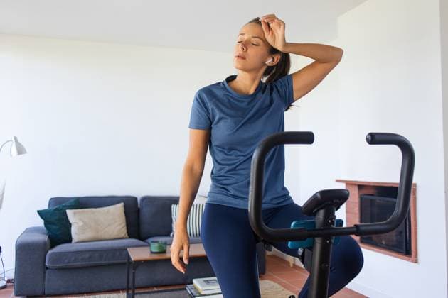 Tired Woman on Stationary Bike Working Out at Home Lisbon, Lisbon, Portugal R_IVLE230916-1252159-01 ,model released, Symbolfoto
