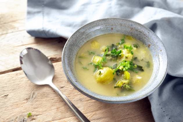 Vegetarian soup from vegetables like brussels sprout, leek and potato with parsley garnish in a blue bowl, spoon and napkin on a rustic wooden table, copy space, selected focus Vegetarian soup from vegetables like brussels sprout, leek and potato with parsley garnish in a blue bowl, spoon and napkin on a rustic wooden table, copy space, selected focus, narrow depth of field Copyright: xZoonar.com MARENxWINTERx 20515400