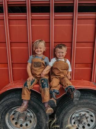 IMAGO Creative, Kinder auf dem Reiterhof Brother and sister hanging out on a red horse trailer Wilsall, Montana, United States CR_BAEK231005-1254616-01 ,model released, Symbolfoto