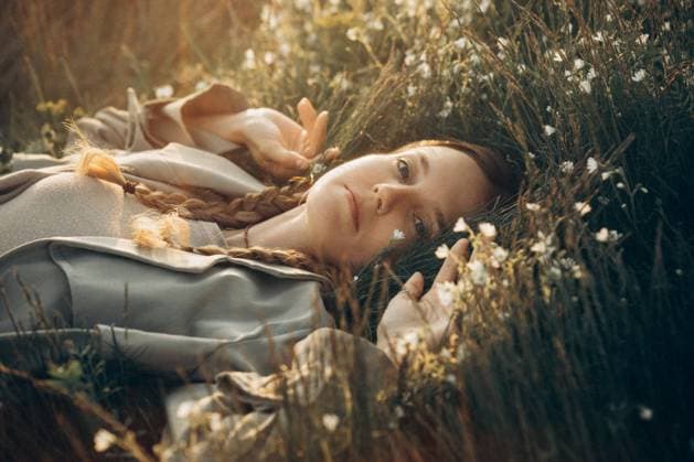 Creative Highlights Symbolbilder Young woman lies in the grass and flowers at sunset Prague, Prague, Czechia CR_UJEL23100724-1264596-01 ,model released, Symbolfoto