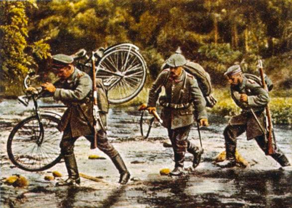 RECORD DATE NOT STATED WWI GERMAN TROOPS German troops, one carrying his bicycle, cross a stream as they move into Eastern France. Date: 1914  Copyright: Gemini Picture No. 10094710
