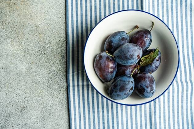 IMAGO Creative, Jahreszeit Sommer, Food, Pflaume Top view of ripe plums served in ceramic bowl on striped napkin against gray surface Model Released AnnaBogush_ID17000_518396_004 Copyright: xAnnaxBogushx