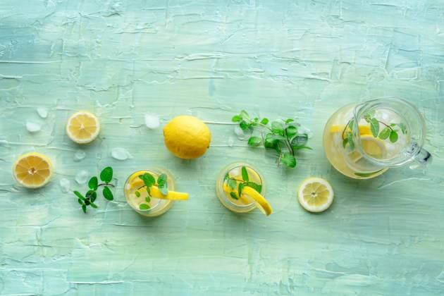Lemonade with mint. Lemon water drink with ice. Two glasses and a pitcher Lemonade with mint. Lemon water drink with ice. Two glasses and a pitcher on a blue background, overhead flat lay shot. Detox beverage. Fresh homemade cocktail Copyright: xZoonar.com KaterinaxSolovyevax 20530516