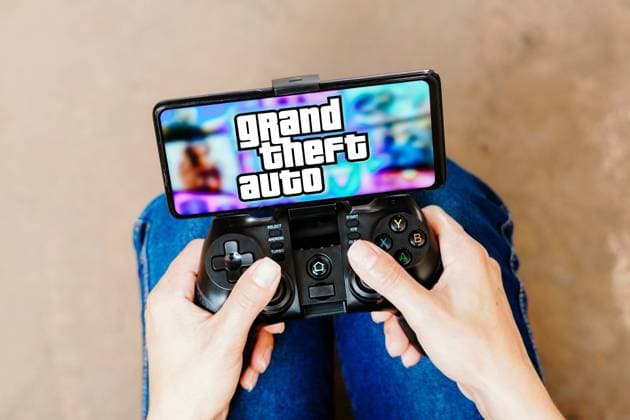 August 8, 2023, Brazil. In this photo illustration, a person playing on a joystick and the Grand Theft Auto (GTA) logo displayed on a smartphone screen. August 8, 2023, Brazil. In this photo illustration, a person playing on a joystick and the Grand Theft Auto (GTA) logo displayed on a smartphone screen Copyright: xZoonar.com rafapressx 20609236