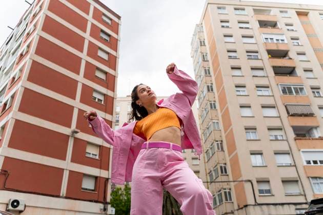 Fashionable woman dancing in front of building model released, Symbolfoto, AFVF09286