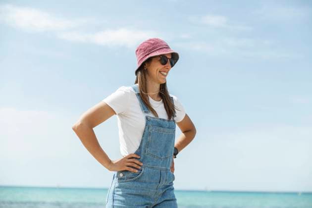 Smiling woman with arms akimbo standing near sea under sky model released, Symbolfoto, PCLF00663