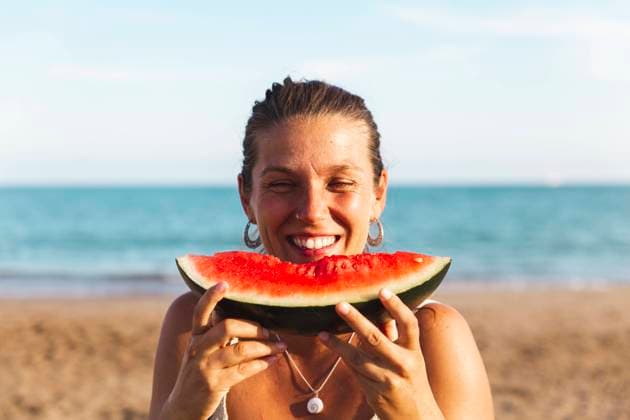Happy woman enjoying watermelon at beach model released, Symbolfoto, PCLF00715