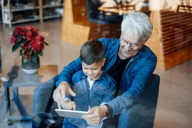 Boy using tablet PC sitting with grandfather at home model released, Symbolfoto property released, JOSEF21105