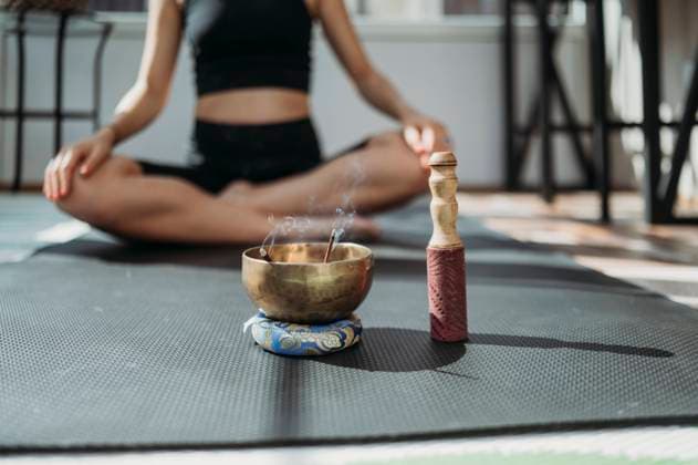 Incense burning in rin gong with woman exercising on mat in background model released, Symbolfoto property released, ANAF02170