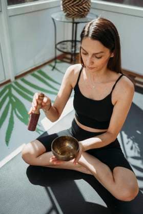 Woman practicing music therapy with rin gong in hand at home model released, Symbolfoto property released, ANAF02181