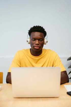 Tschechien, Hochschule streicht wegen KI und Plagiate Bachelorarbeiten Student wearing wireless headphones using laptop at desk model released, Symbolfoto property released, EBSF03862