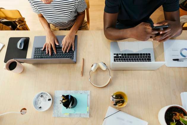 Tschechien, Hochschule streicht wegen KI und Plagiate Bachelorarbeiten Young student typing on laptop with friend using smart phone at desk model released, Symbolfoto property released, EBSF03873