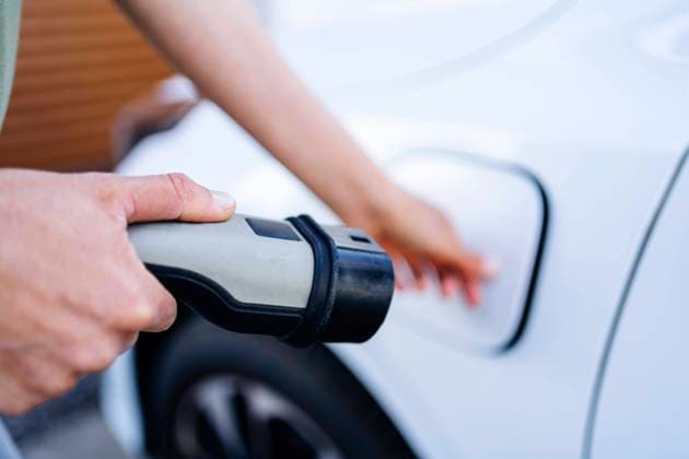 Woman holding plug near electric car model released, Symbolfoto property released, DIGF20870