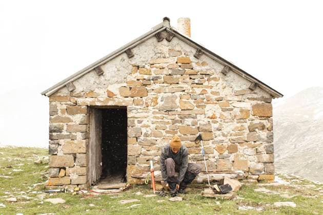 Creative Highlights Symbolbilder Man tying shoe near brick house on mountain model released, Symbolfoto, PCLF00855