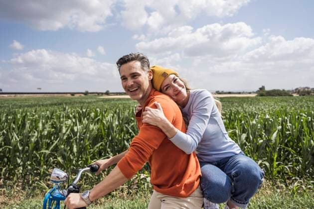 Happy woman embracing man in front of field model released, Symbolfoto, UUF29680