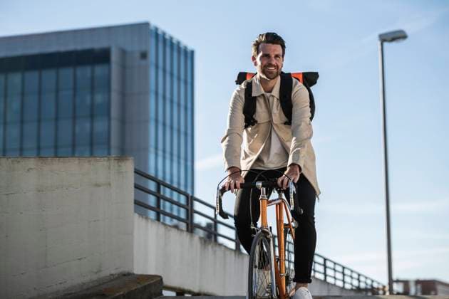 Man riding bicycle in front of building and sky model released, Symbolfoto, UUF30507
