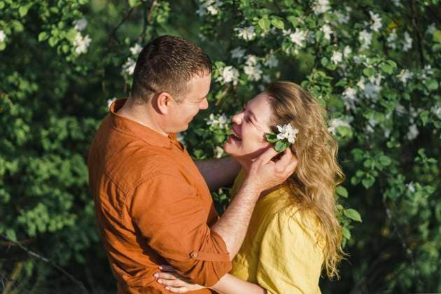 IMAGO Creative: Sommer, Sommertage im Garten Smiling couple standing in front of blossoming tree model released, Symbolfoto, VBUF00388