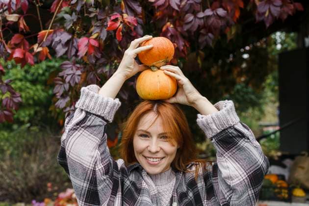 Happy redhead farmer holding pumpkins on head at farm model released, Symbolfoto property released, VBUF00421