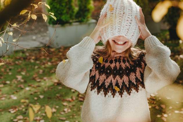 Smiling girl covering face with knit hat in garden model released, Symbolfoto, YTF01060
