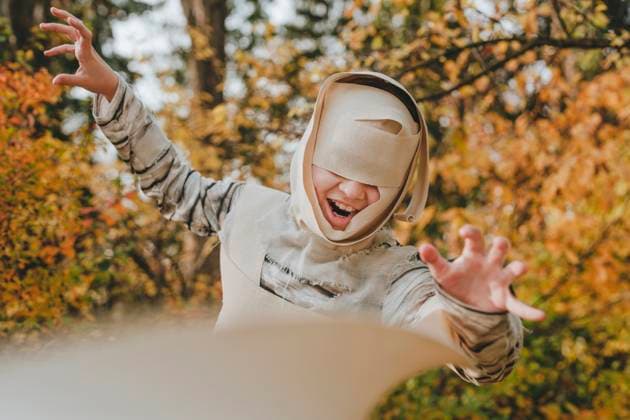 Joyful girl wearing mummy costume and gesturing in garden model released, Symbolfoto, YTF01063