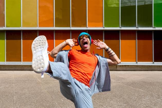 Joyful man dancing energetically in front of a multicolored windowed building Model Released SergioVictorVega_ID16857_514943_015 Copyright: xSergioxVictorxVegax