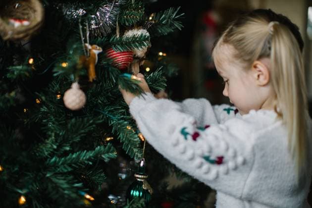 Curious girl in white sweater explores Christmas ornaments. Boise, Idaho, United States CR_AUAU231023-1274550-01 ,model released, Symbolfoto