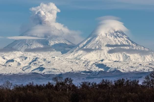RUSSIA, KAMCHATKA REGION - OCTOBER 25, 2023: A view of Kamen dormant stratovolcano and an erupting Klyuchevskaya Sopka (Klyuchevskoi) active stratovolcano. Yelena Vereshchaka TASS  63941884