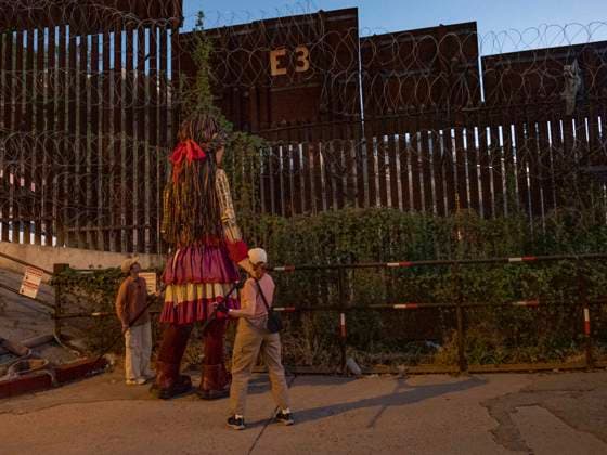 October 27, 2023, Nogales, Arizona, USA: Little Amal, the 12 foot puppet of a Syrian refugee girl, looks at the newly reinforced border wall separating the United States and Mexico. Little Amal is on a 6000 mile journey across the United States to call attention to the plight of migrants and refugees while collaborating with local arts and community organizations. Nogales USA - ZUMAd155 20231027_znp_d155_020 Copyright: xSuexDorfmanx