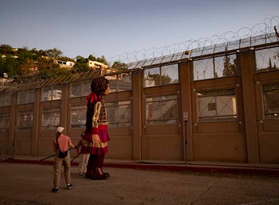 October 27, 2023, Nogales, Arizona, USA: Little Amal, the 12 foot puppet of a Syrian refugee girl, looks at a soccer ball caught in the concertina wire topping the newly reinforced border wall separating the United States and Mexico. Little Amal is on a 6000 mile journey across the United States to call attention to the plight of migrants and refugees while collaborating with local arts and community organizations. Nogales USA - ZUMAd155 20231027_znp_d155_018 Copyright: xSuexDorfmanx