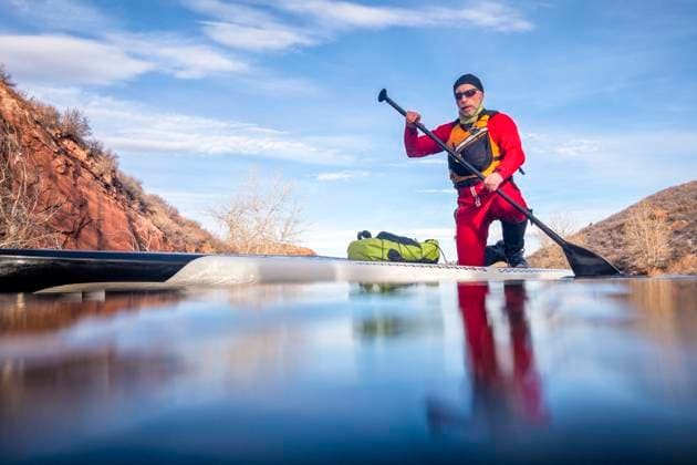 IMAGO Creative, Winter, Winterspaß, Eishockey stand up paddling winter training senior male paddler in a dry suit and life jacket with a stand up paddleboard on a mountain lake in winter conditions - Horsetooth Reservoir in northern Colorado, low angle POV from a partially submerged action camera ,model released, Symbolfoto Copyright: xZoonar.com MarekxUliaszx 14994818 ,model released, Symbolfoto ,property released