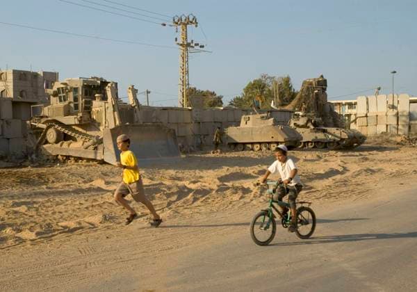 Isarel. Gaza strip. Gush Katif (settlements). Kfar Darom. children playing infront of a row of army vehicles (buldozer, tank...) Isarel. Gaza strip. Gush Katif (settlements). Kfar Darom. children playing infront of a row of army vehicles (buldozer, tank...), Credit:Eitan Simanor Avalon  Copyright: xEitanxSimanorx xAvalonx 0512132995