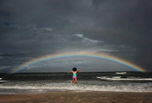 Young girl jumping in the ocean under rainbow Avon, North Carolina, United States CR_JOKU231105-1281095-01 ,model released, Symbolfoto