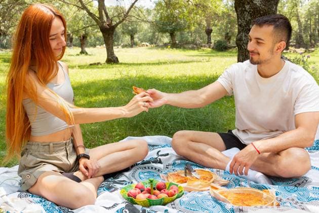 MR_ID17146_15419_JaimePineda.jpg, MR_ID17146_15418_NataliaPenado.jpg Young couple enjoying a picnic in a sunny park, sharing food and moments together under a tree in summer day Model Released GemaAlejo_ID17146_522142_001 Copyright: xGemaxAlejox