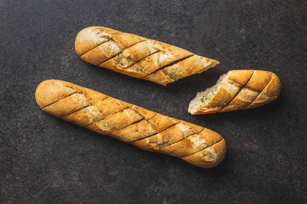 Roasted baguette with garlic butter. Crunchy sliced garlic bread on black table. Roasted baguette with garlic butter. Crunchy sliced garlic bread on black table. Top view. Copyright: xZoonar.com JIRIxHERAx 18194348
